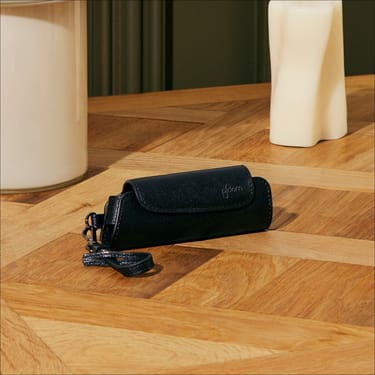 Ploom AURA Jet Black torbic s jednim pretincem na stolu